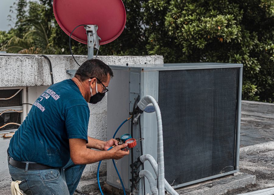 Technicien vérifiant la pression d'une unité extérieure de climatisation
